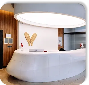 The reception desk under the round ceiling light, the EFC wings on the wall behind it