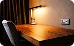 A writing desk and chair by the curtains