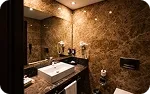 A marble bathroom, the basin under a lit mirror